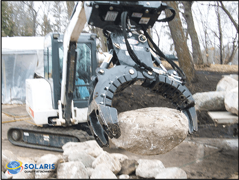 excavator lifting rocks standing on a base